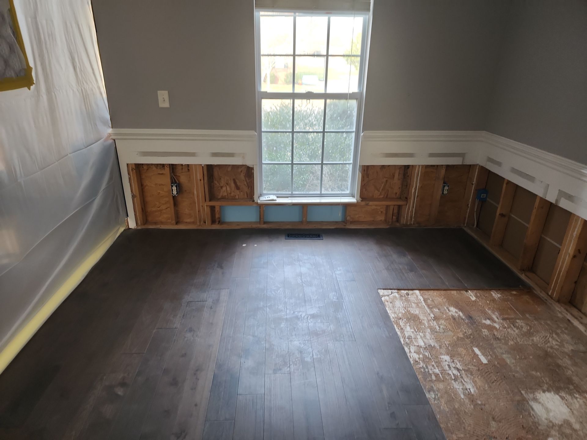 Reconstruction In Progress — New flooring installed, walls prepped for finish.